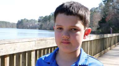 Close up of Levi standing with a lake in the background